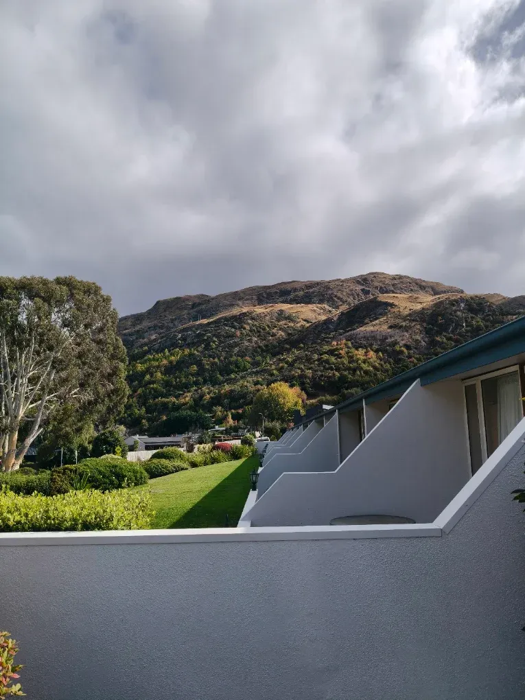 Grey exterior plaster walls with the hills behind
