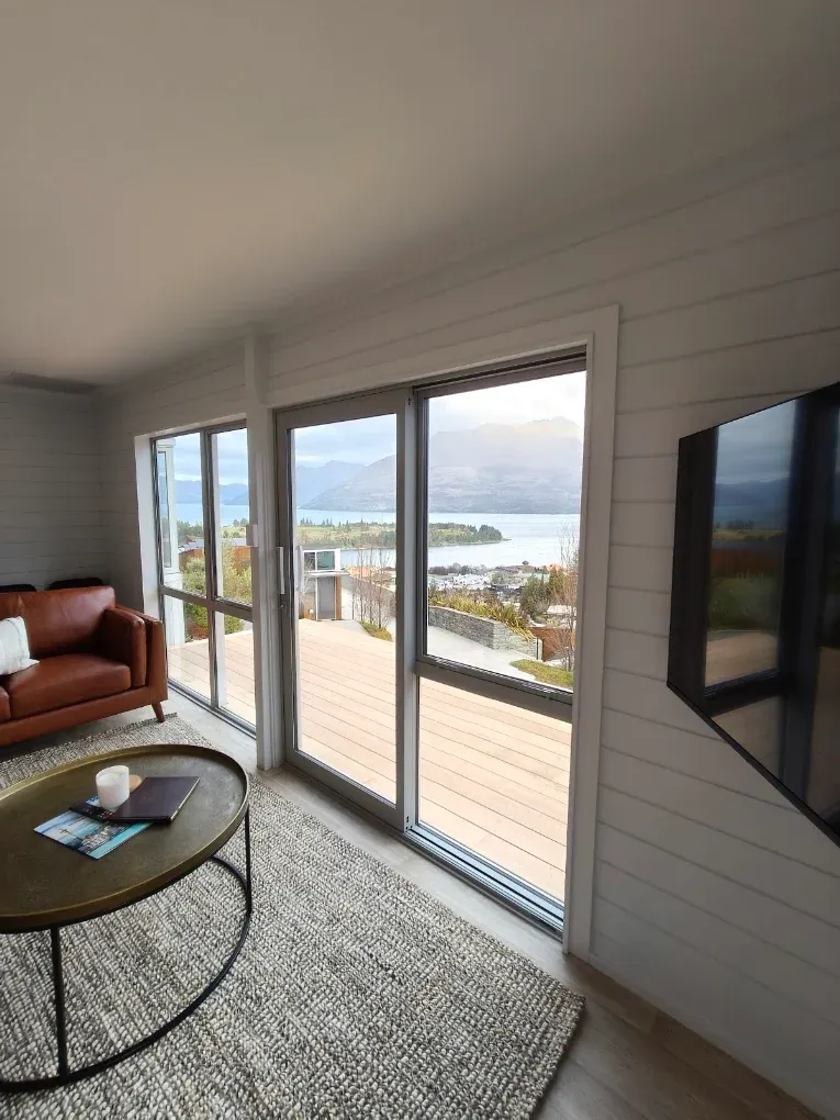 Living room with tan leather sofa and lake view