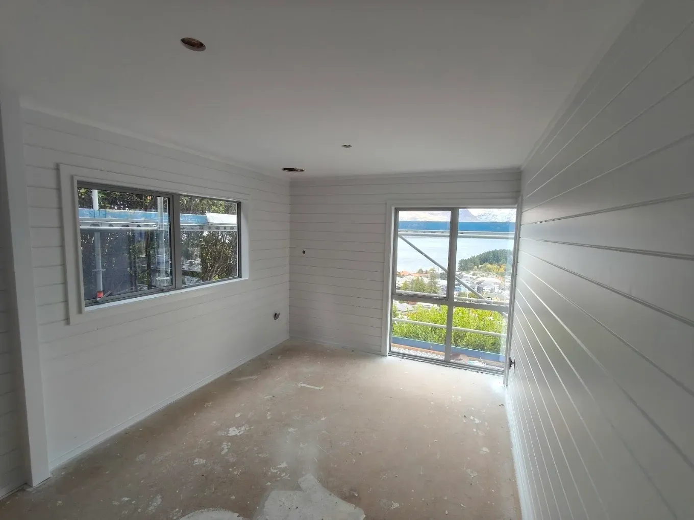 Empty room mid-job with drop sheets and lake view