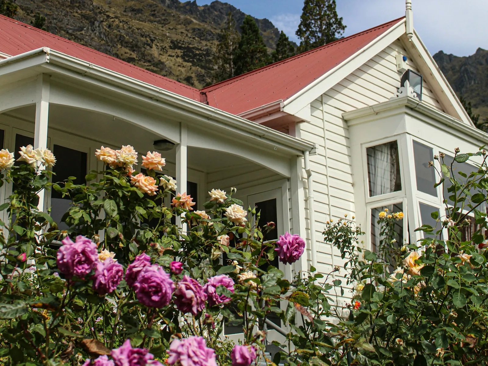 White weatherboard villa exterior repaint with a red roof