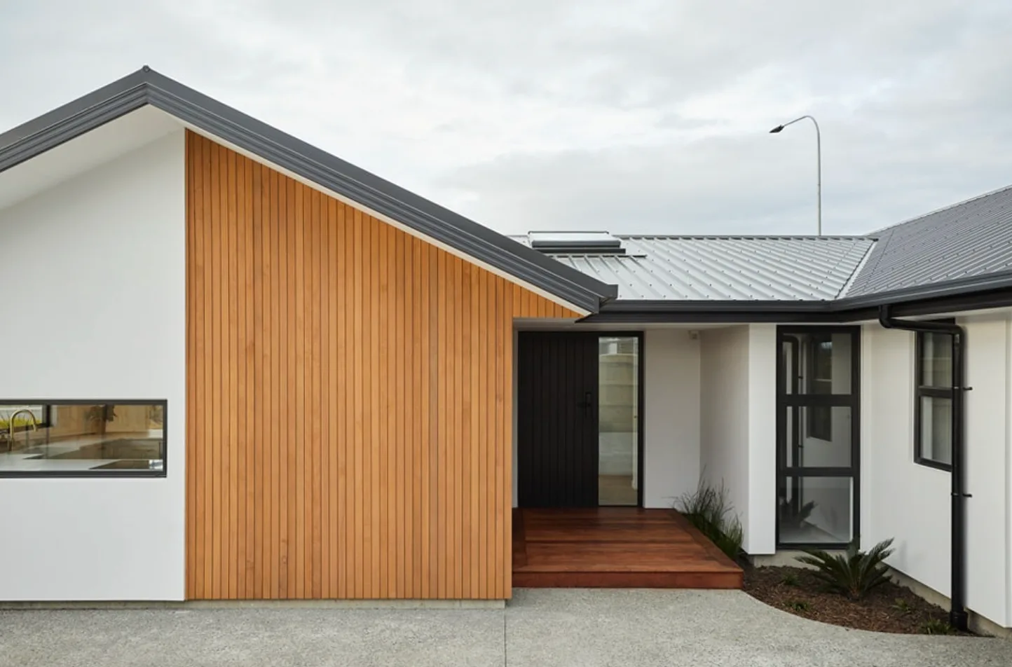 Entryway with vertical cedar cladding and a timber deck